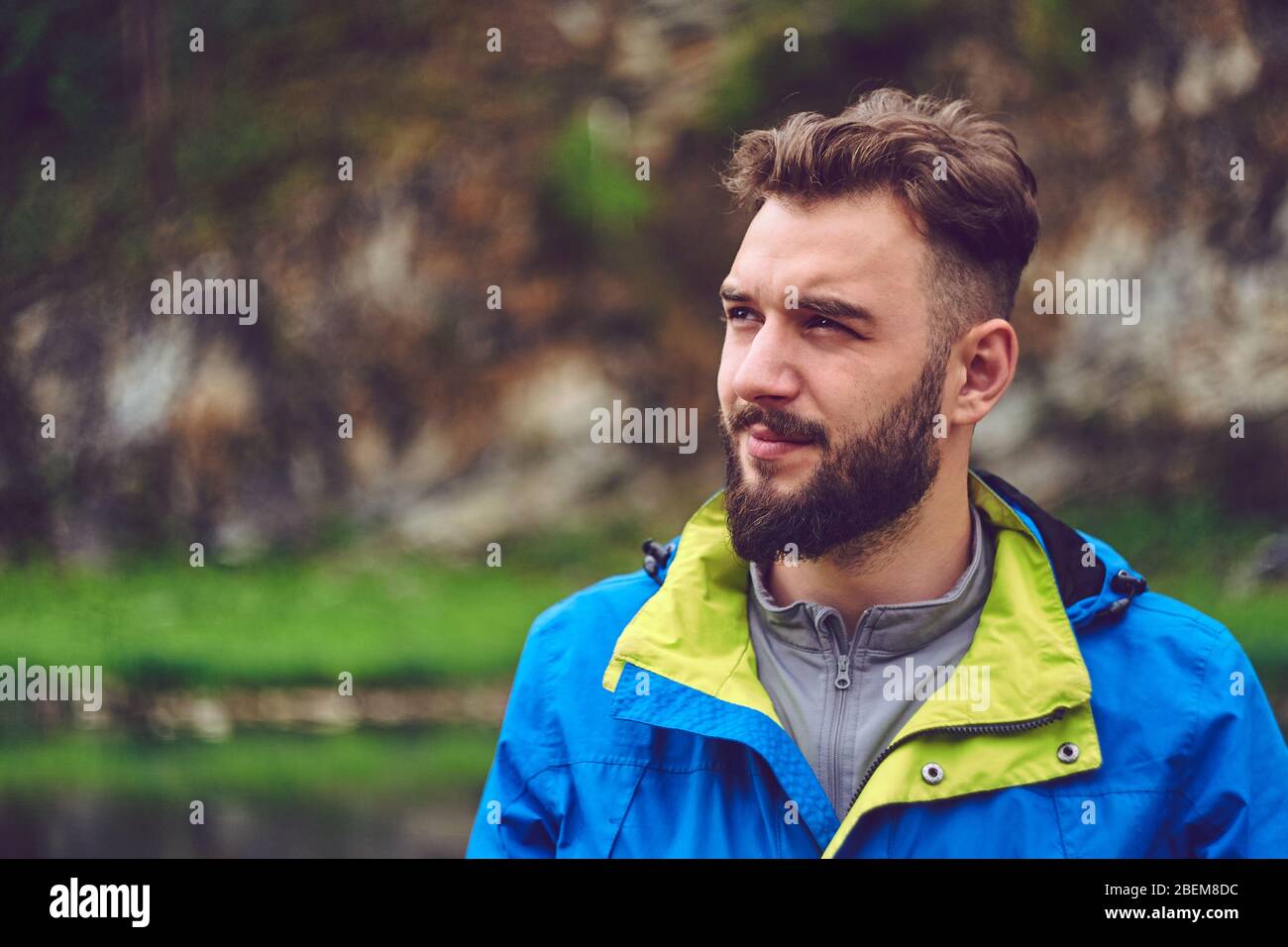 Porträt eines jungen, bärtigen Mannes, auf, vor einem Hintergrund der Tierwelt. Das Konzept von Expedition, Abenteuer und Camping-Leben. Stockfoto