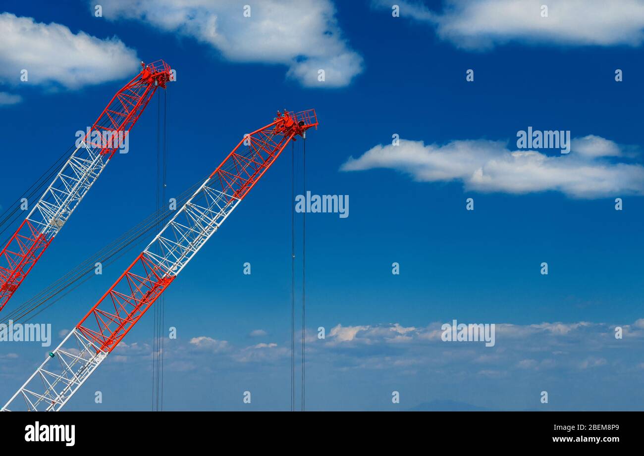 Bauindustrie und Entwicklung. Zwei Kraniche bei der Arbeit zwischen Wolken (mit Kopierraum) Stockfoto