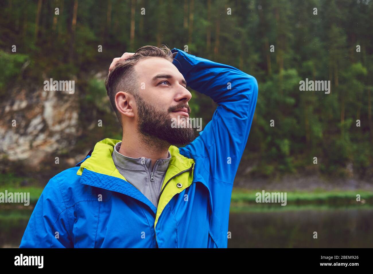 Porträt eines jungen, bärtigen Mannes, auf, vor einem Hintergrund der Tierwelt. Das Konzept von Expedition, Abenteuer und Camping-Leben. Stockfoto