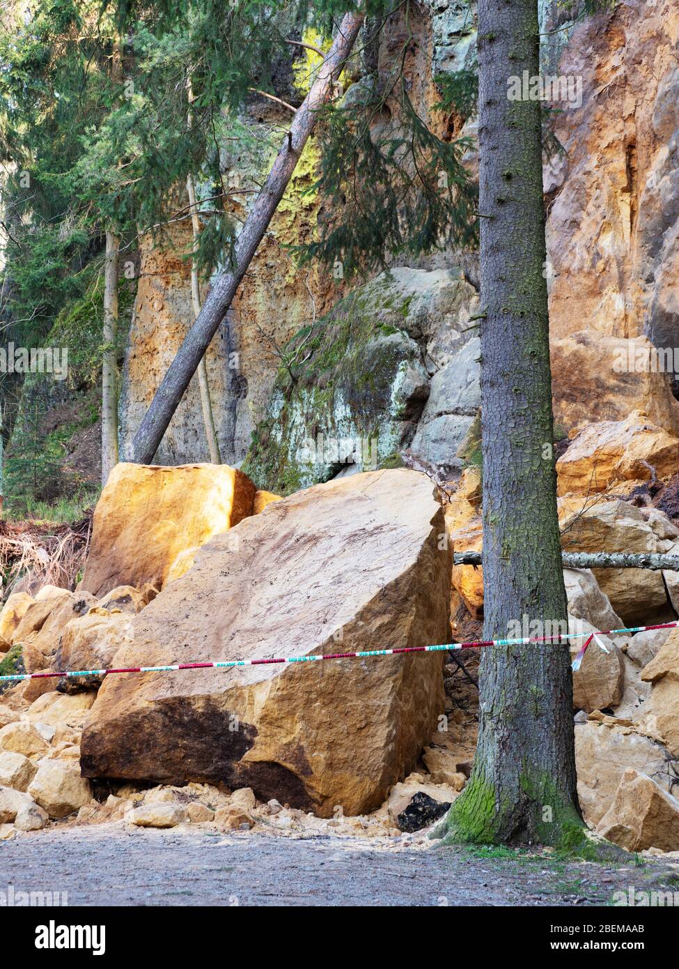 Keine Eingangszone. Zerbrochene Felsmassive von Hügel. Auf der Waldstraße stürzte Sandsteinmassiv ab. Geschlossener Bereich mit Polizeiband markiert. Stockfoto
