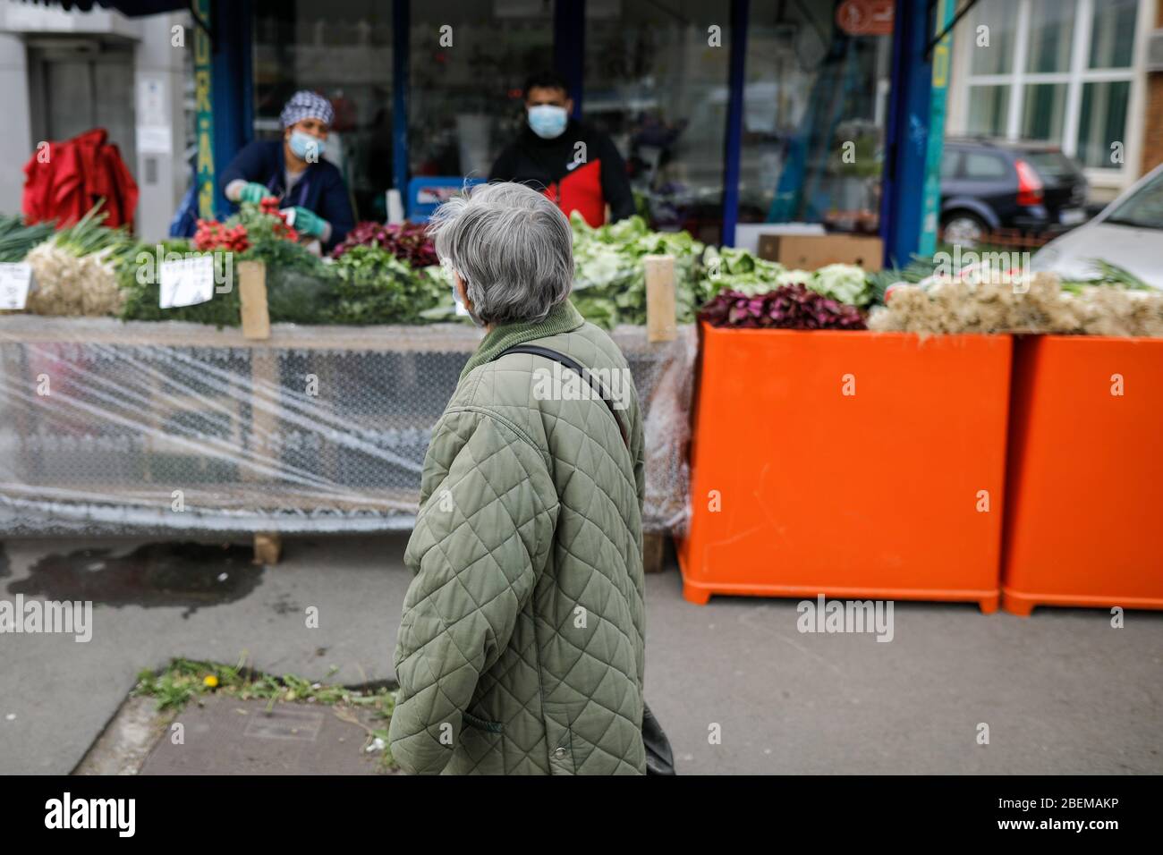 Bucharest, Romania - April 14, 2020: Senior woman walks by a street vegetable market during the covid-19 lockdown. Stockfoto