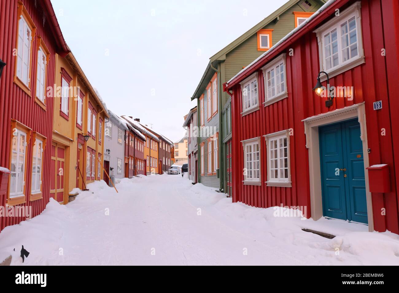 Bunte traditionelle Häuser entlang einer schneebedeckten Straße im Zentrum der historischen Bergbaustadt Røros, Norwegen. Stockfoto