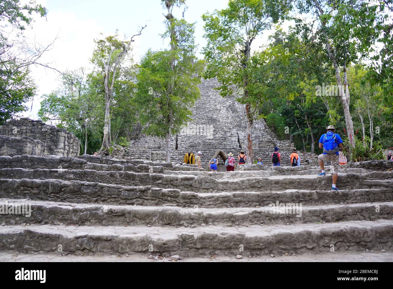 COBA MAYA RUINEN, Mexiko - Besucher steigen Steintreppen in La Iglesia (die Kirche), eine der größeren Strukturen in Coba Stockfoto