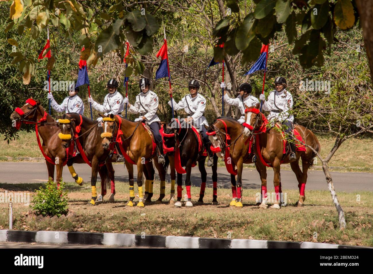 Chandigarh / Indien / 04. April 2017: Reitergruppe auf Pferden mit blauem und rotem Fack in der Sonne Stockfoto