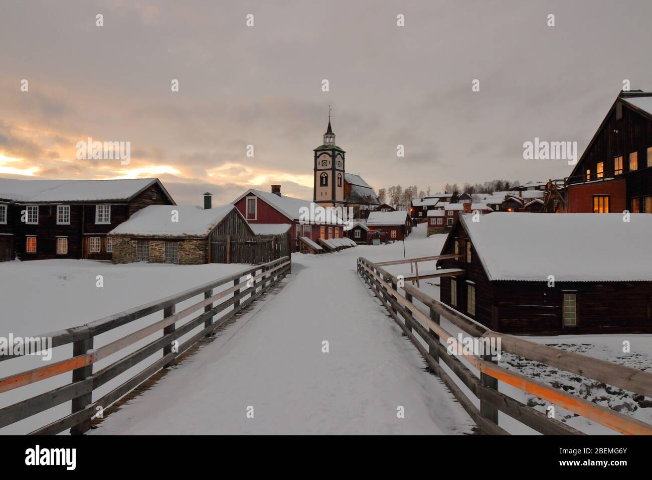 Blick auf die historische Bergbaustadt Røros mit der Kirche Bergstadens Ziir und traditionellen Holzhäusern im Winter, Norwegen. Stockfoto