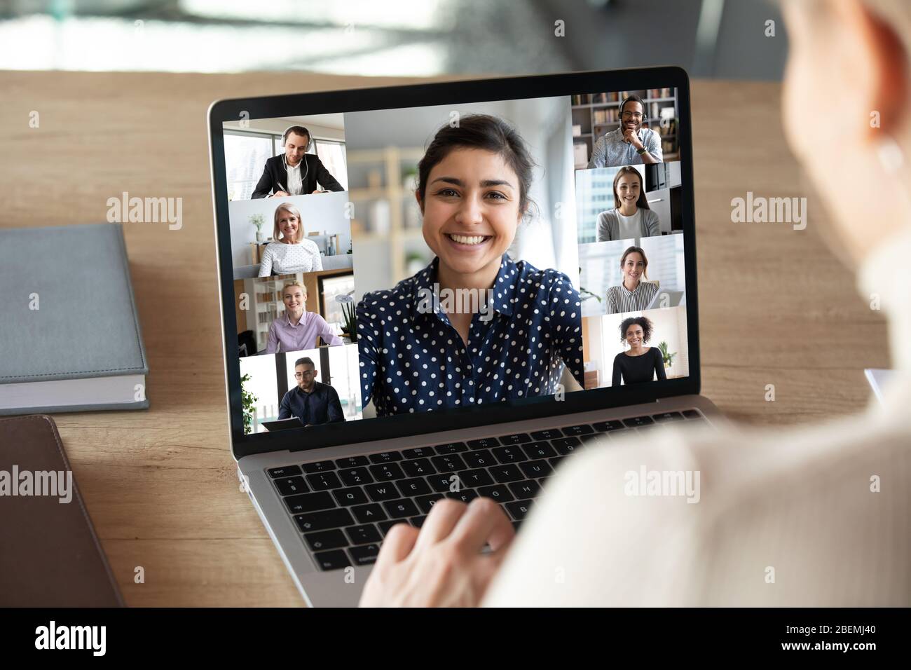 Laptop-Bildschirm über der Schulter der Frau während der Online-Kommunikation in der Gruppe Stockfoto