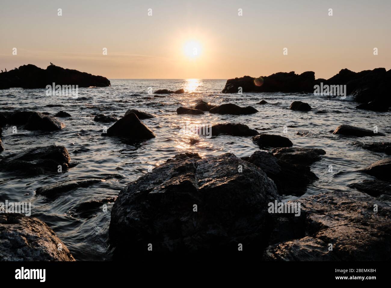 Panorama-Shot Silhouette der Meer Stack Felsformationen bei einem goldenen Sonnenuntergang mit natürlichen Sonnenstrahlen und Reflexionen Stockfoto
