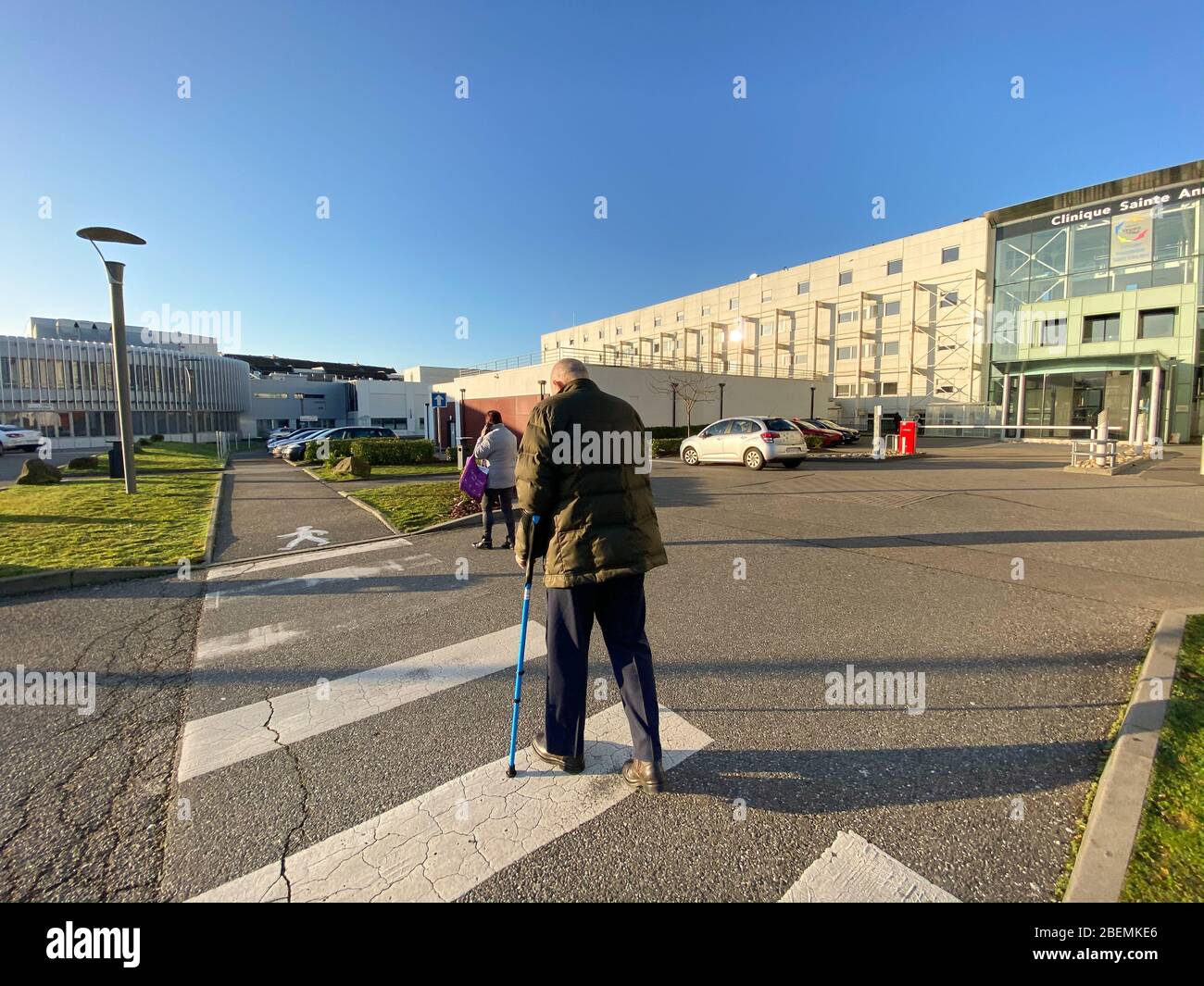 Straßburg, Frankreich - 20. Jan 2020: Seitenansicht der Patienten Senior mit zwei Spazierstöcken vor dem französischen Krankenhaus in Straßburg Sainte Anne Stockfoto