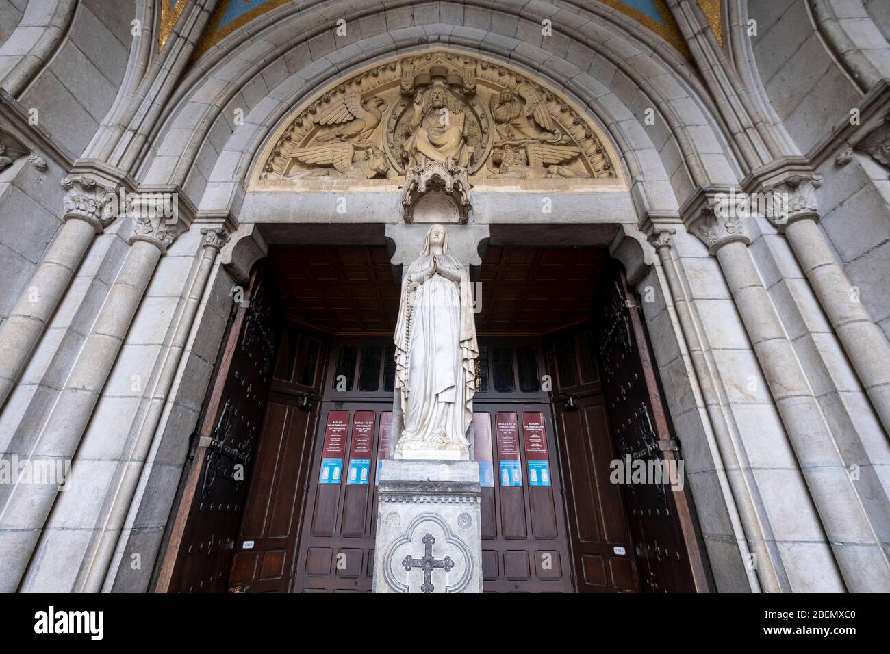 Skulptur der Jungfrau Maria zwischen den Eingangstüren der Basilika unserer Lieben Frau vom Rosenkranz in Lourdes, Frankreich, Europa Stockfoto