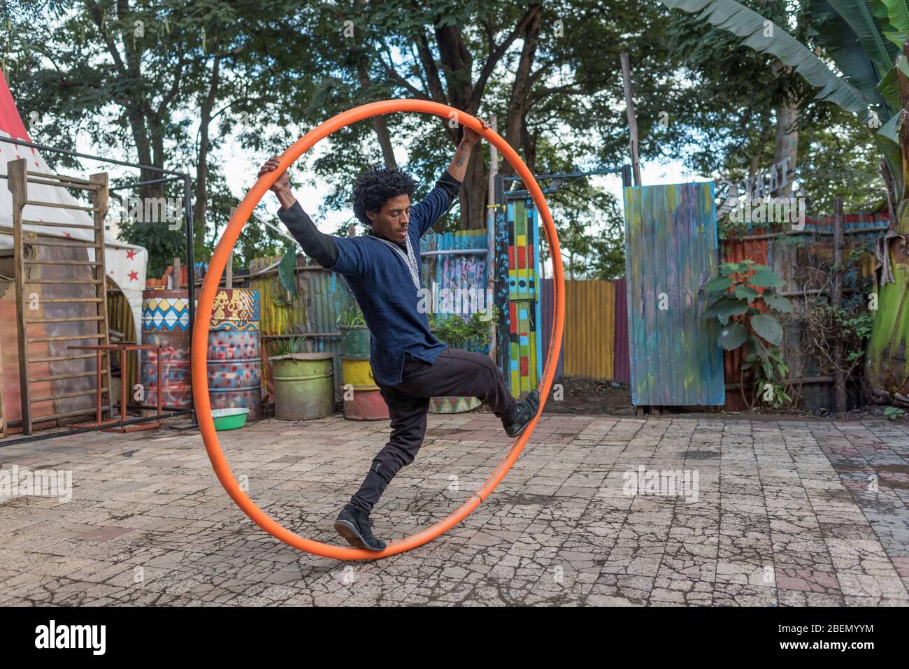 Der junge Mann übt das Balancieren auf Spinning Loop in der Schule und dem Gemeindezentrum des Fekat Circus in Addis Abeba, Äthiopien, Afrika. Stockfoto