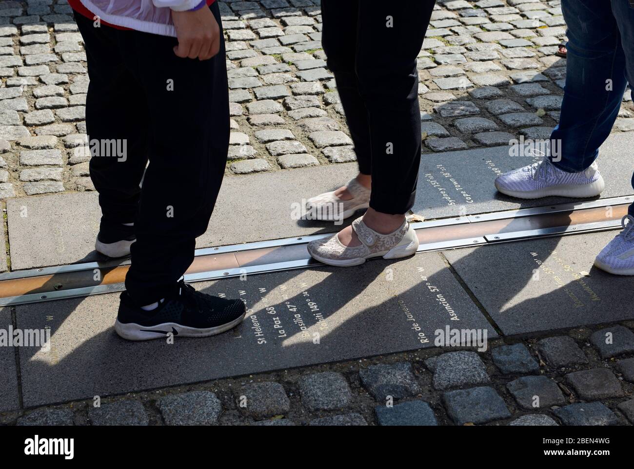 Die Menschen fahren auf der Greenwich Meridian Linie am Greenwich Royal Observatory in London, Großbritannien Stockfoto