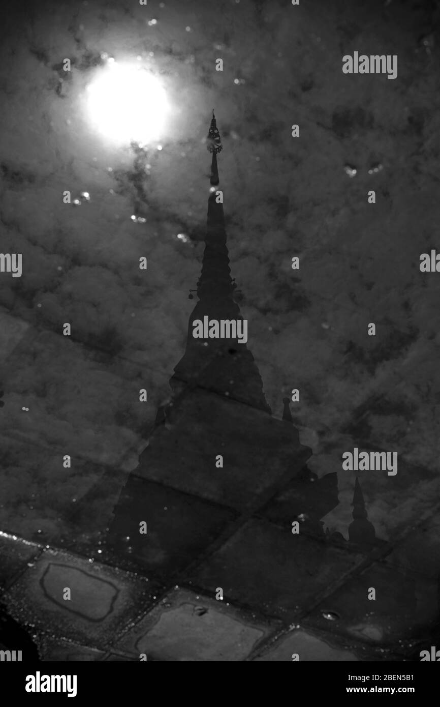 Silhouette des Wat Phra Borommathat Chaiya, einer alten Stupa, spiegelt sich auf dem Regenbecken in Chaiya, Surat Thani, Thailand. Stockfoto