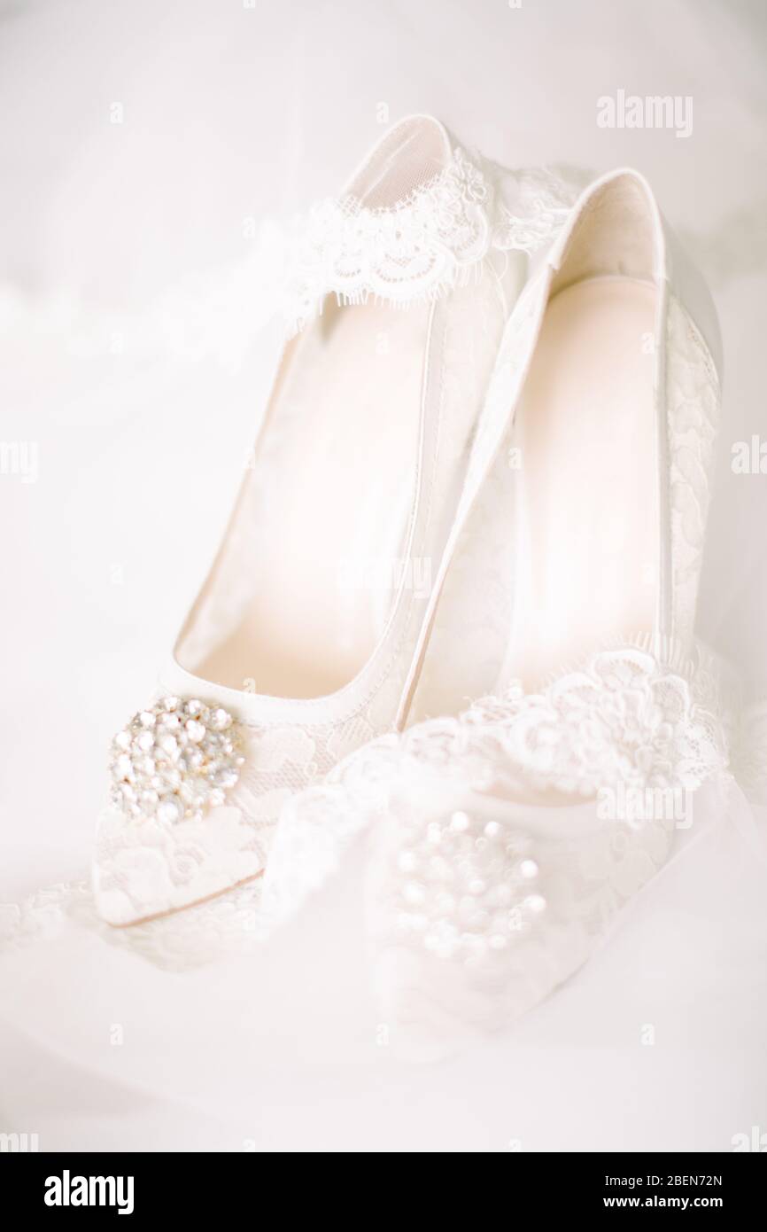 Brautschuhe auf Tüll. Edelstein und Spitze. Parfümflasche. Stockfoto