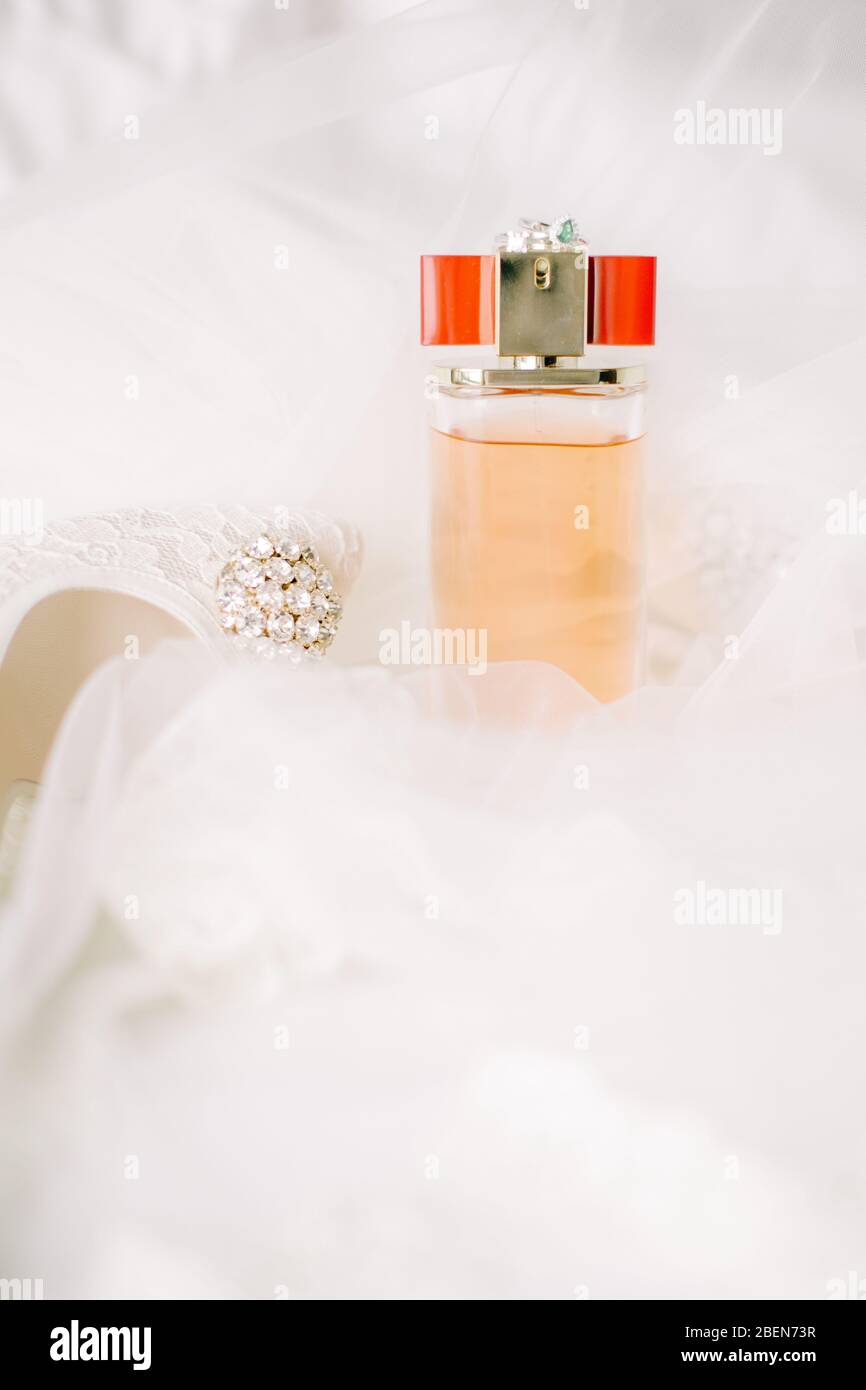 Brautschuhe auf Tüll. Edelstein und Spitze. Parfümflasche. Stockfoto