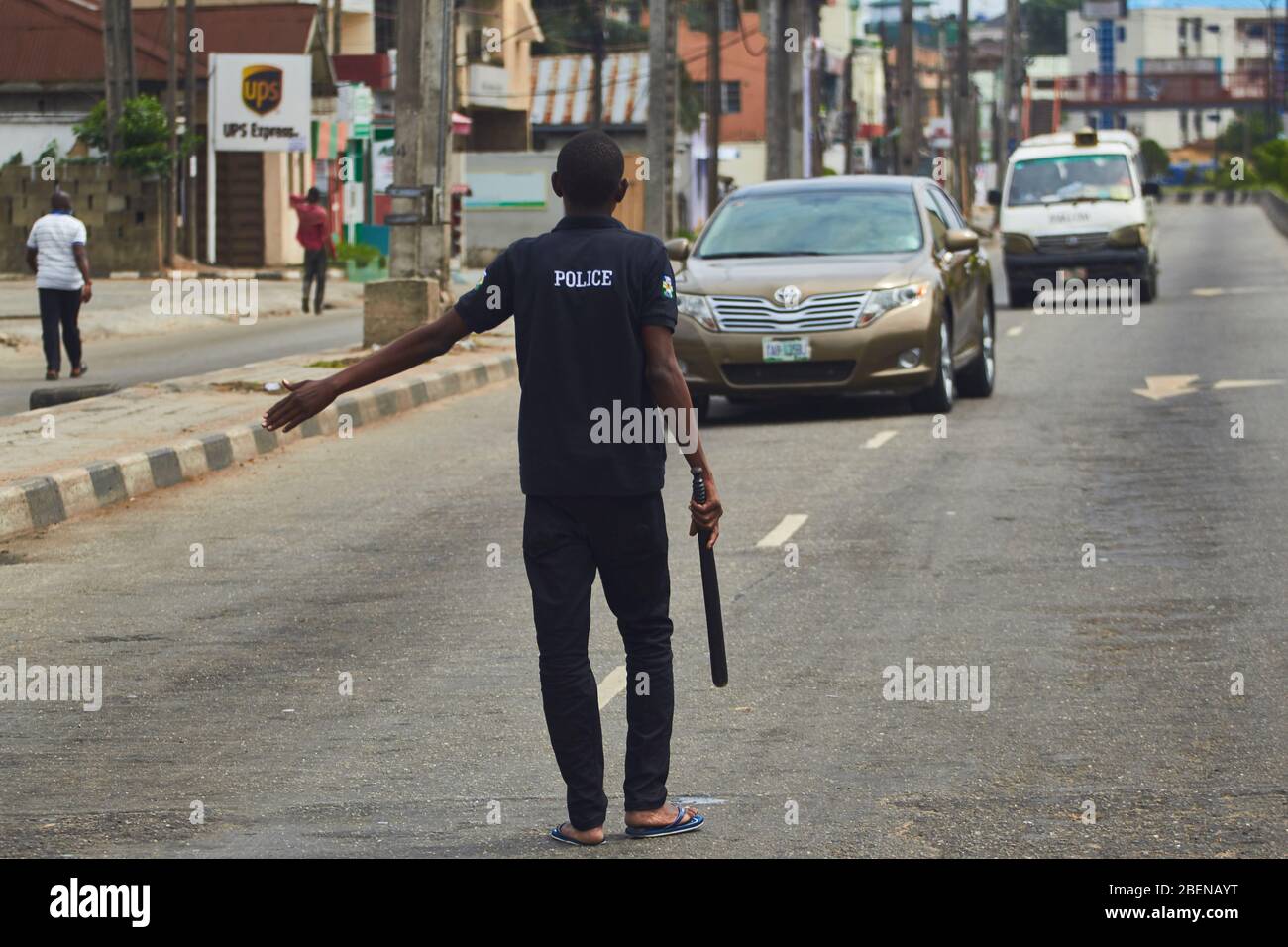 Ein Polizist hält Fahrzeuge an, um zu überprüfen, ob sie über Anmeldeinformationen verfügen, die es ihnen ermöglichen, sich während einer Covid-19-Sperre in Lagos, Nigeria, zu bewegen. Stockfoto