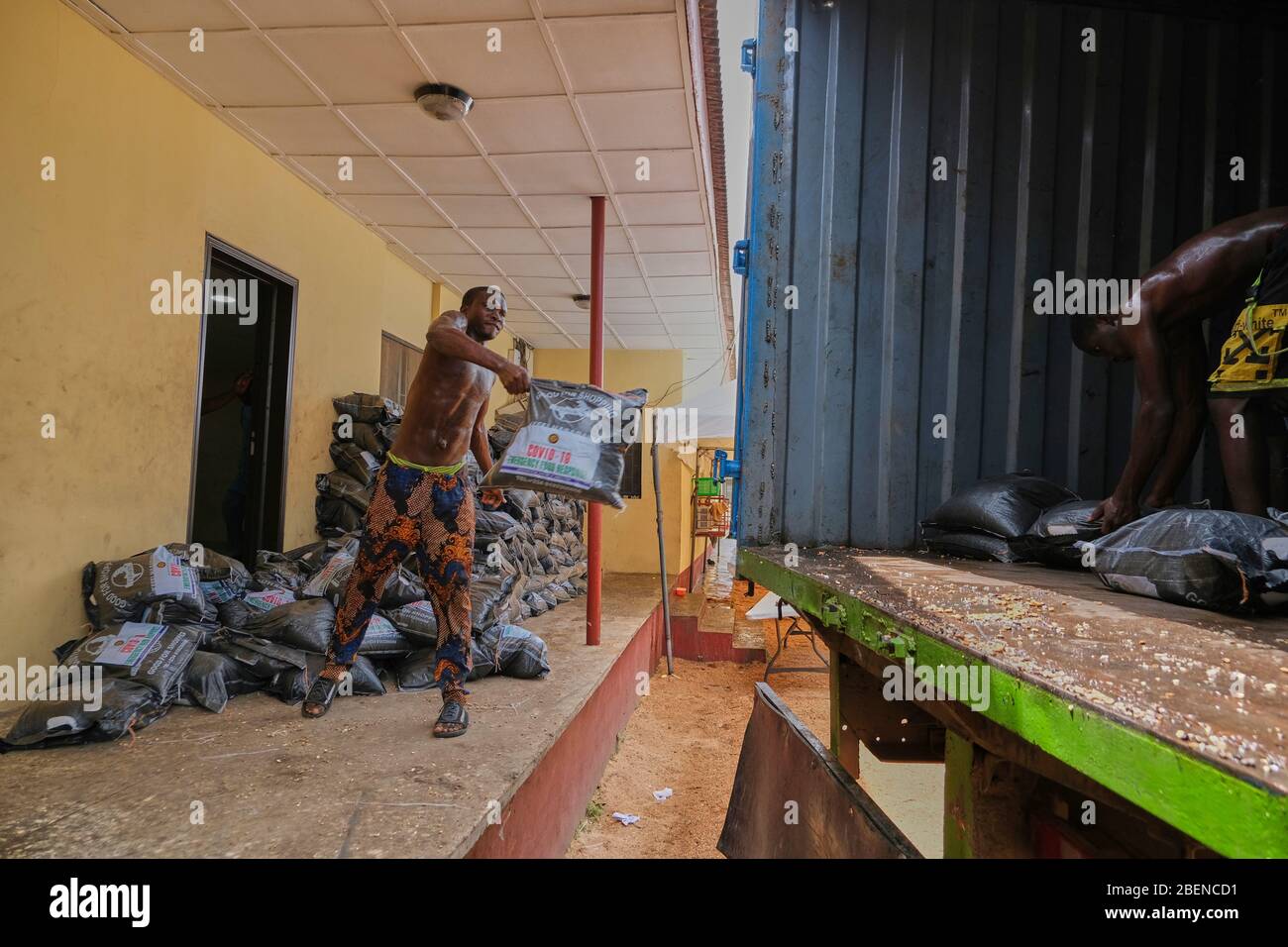 Arbeiter laden Lebensmittelpakete in einen LKW im Lagerhaus des Landwirtschaftsministeriums von Lagos, wo die Covid-19-Notfallpackungen für Lebensmittel gelagert werden. Stockfoto
