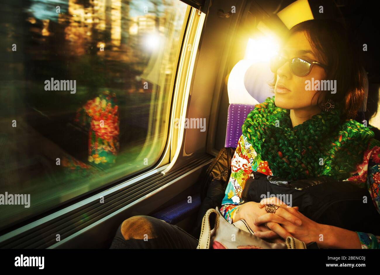 Eine offene Aufnahme einer jungen, schönen Pariser Frau, die in einem Zug unterwegs ist und am Fenster sitzt Stockfoto