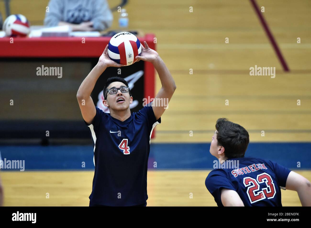 Player Einstellung für einen Mannschaftskameraden während eines längeren Volley. USA. Stockfoto