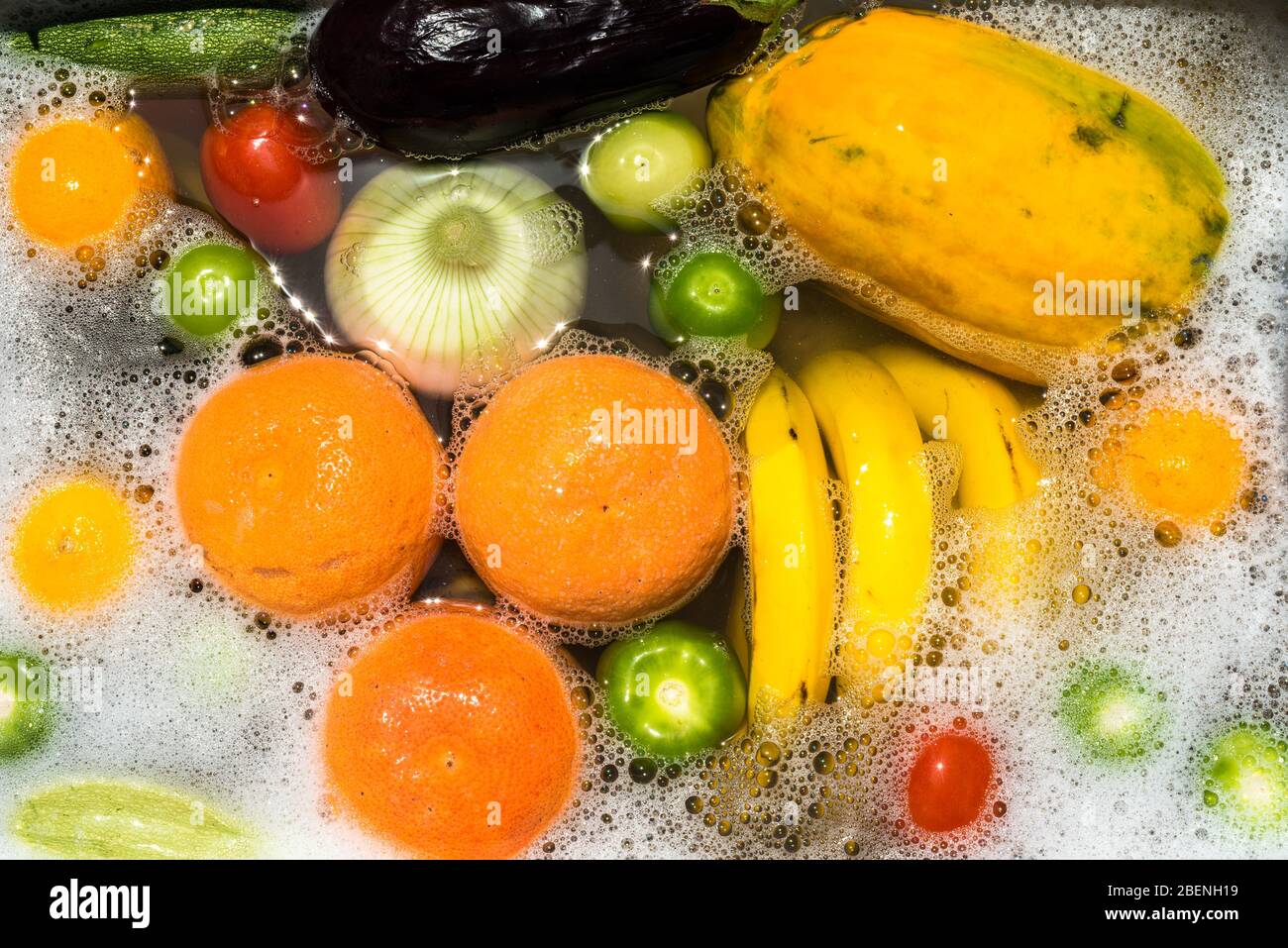 Waschen von Obst und Gemüse in Seifenwasser zur Desinfektion von Coronavirus. Stockfoto