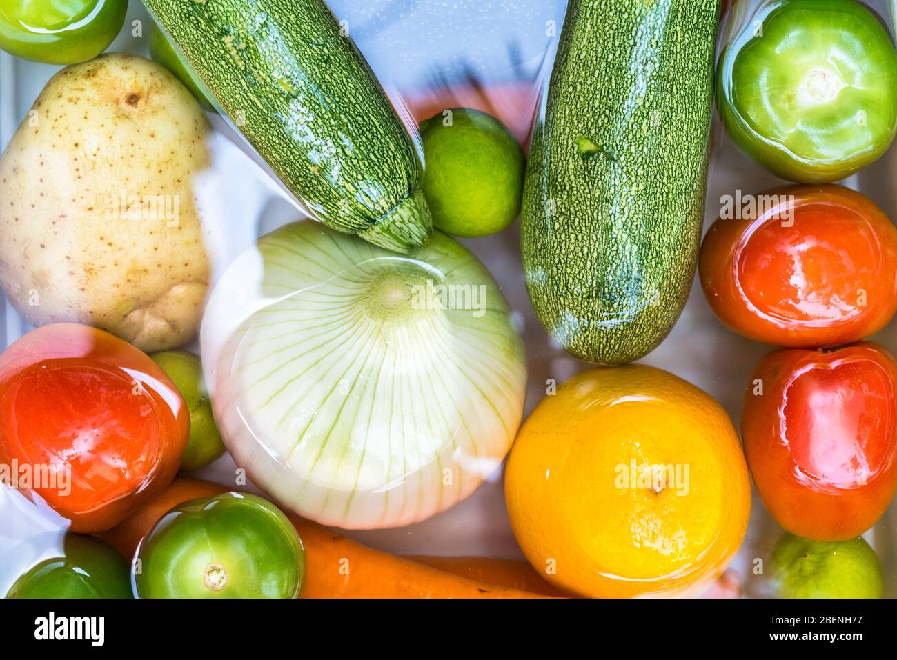 Waschen von Obst und Gemüse in Seifenwasser zur Desinfektion von Coronavirus. Stockfoto