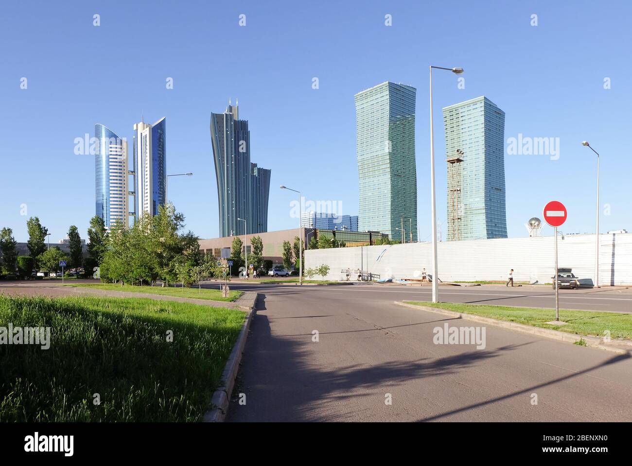 NUR-SULTAN, ASTANA, KASACHSTAN - 3. JUNI 2015: Blick auf die leere Straße mit Skyscapperbauten im Hintergrund bei Tag. Geometrisch Stockfoto