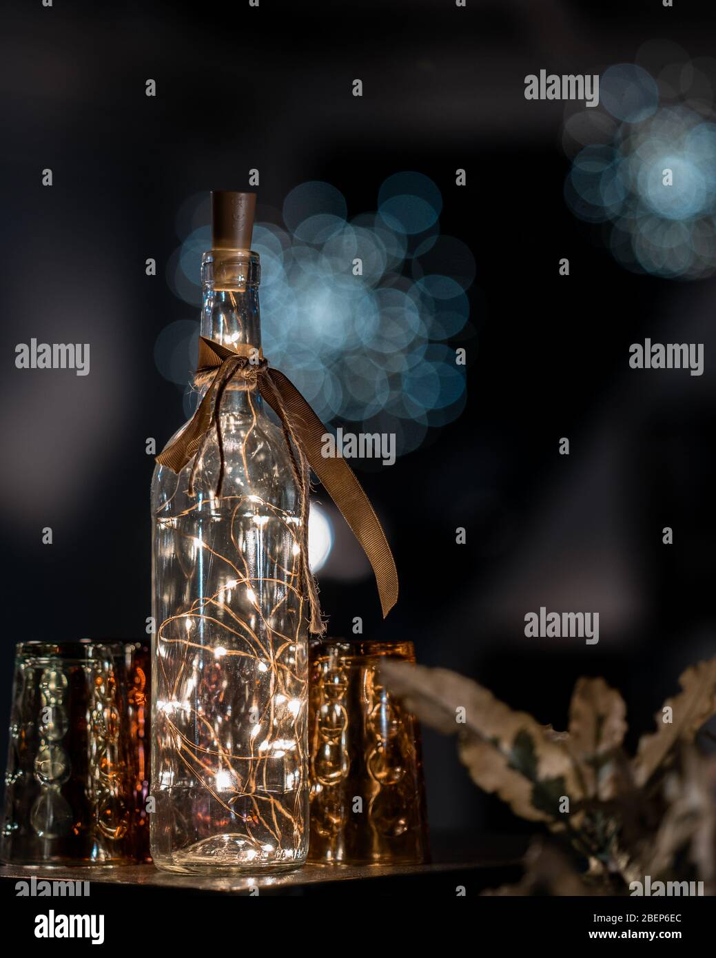 Glasflasche mit Fairy Lights innen und blauem Hintergrund Stockfoto