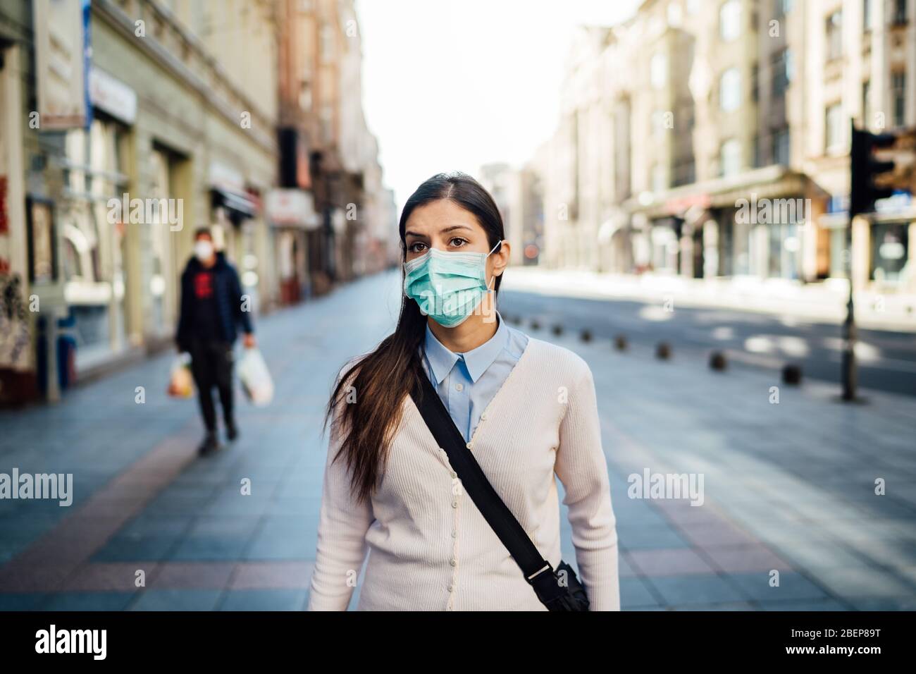 Verdächtige junge Erwachsene, die während der Pandemie im öffentlichen Raum gehen.Wirkung der COVID-19.Schutzmaßnahme, Maske tragen.Richtlinien respektieren.Empty stre Stockfoto