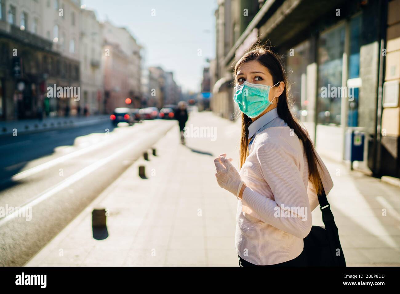 Ängstlich junge Erwachsene durch die COVID-19.Walking betroffen, gehen zur Arbeit während der Pandemie.Protective Maßnahmen, Maske tragen und soziale Distanzierung.Respecting g Stockfoto