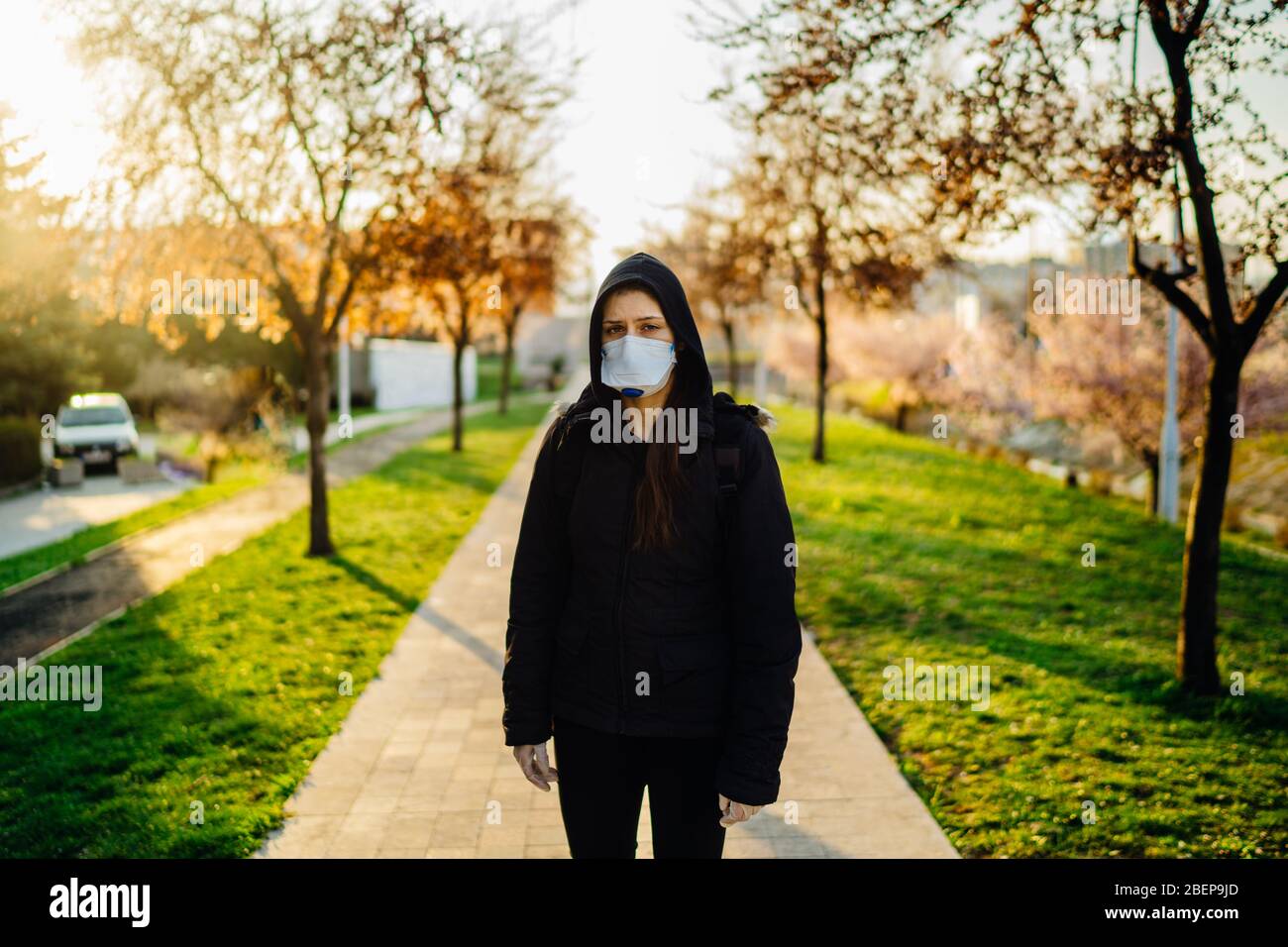 Depressive erschrocken Person trägt eine schützende N95 Maske, um ansteckende Krankheit zu verhindern, die sich im Frühling ausbreitet Natur.Coronavirus pandemic life.Panic und Angst o Stockfoto