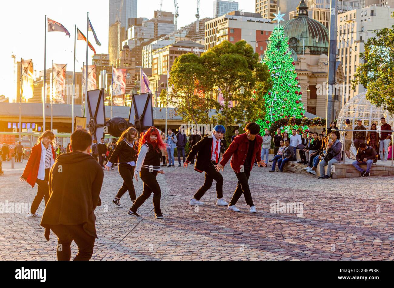 Teenager tanzen und machen Musikvideos während des Sonnenuntergangs am Federation Square, Melbourne Stockfoto