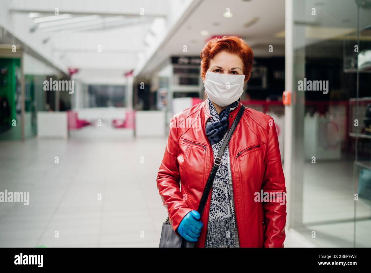 Ältere ältere Frau mit Schutztuch Gesichtsmaske und Handschuhen. Coronavirus COVID-19 Ausbruch ältere Krankheit Infektionsschutz. Großmutter im Ruhestand Stockfoto