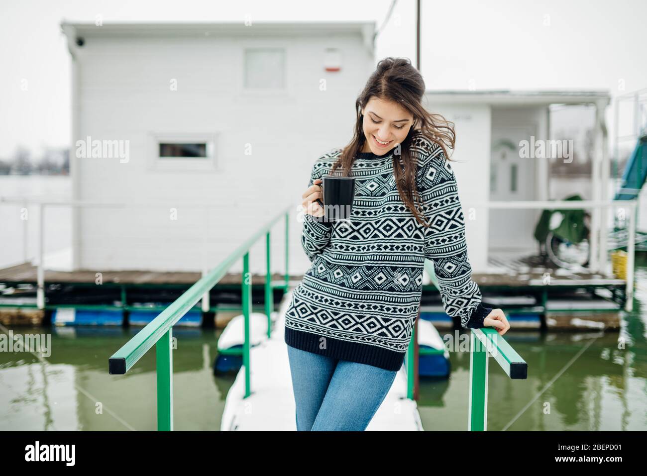 Frau genießen Winterzeit vor dem winzigen Haus, trinken Morgen Kaffee.Happiness.First property.small Apartment.Minimalism.Moving in.Living alone.C Stockfoto