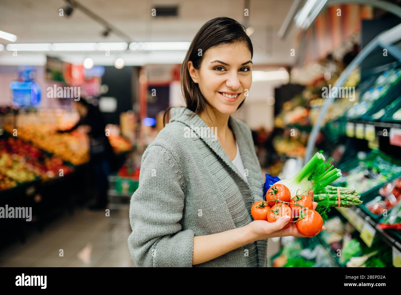 Junge Frau einkaufen im Supermarkt Lebensmittelgeschäft.Kauf von Bio-Gemüse nachhaltige Produkte.natürliche Quelle von Vitaminen und Mineralstoffen.Vegan / vege Stockfoto