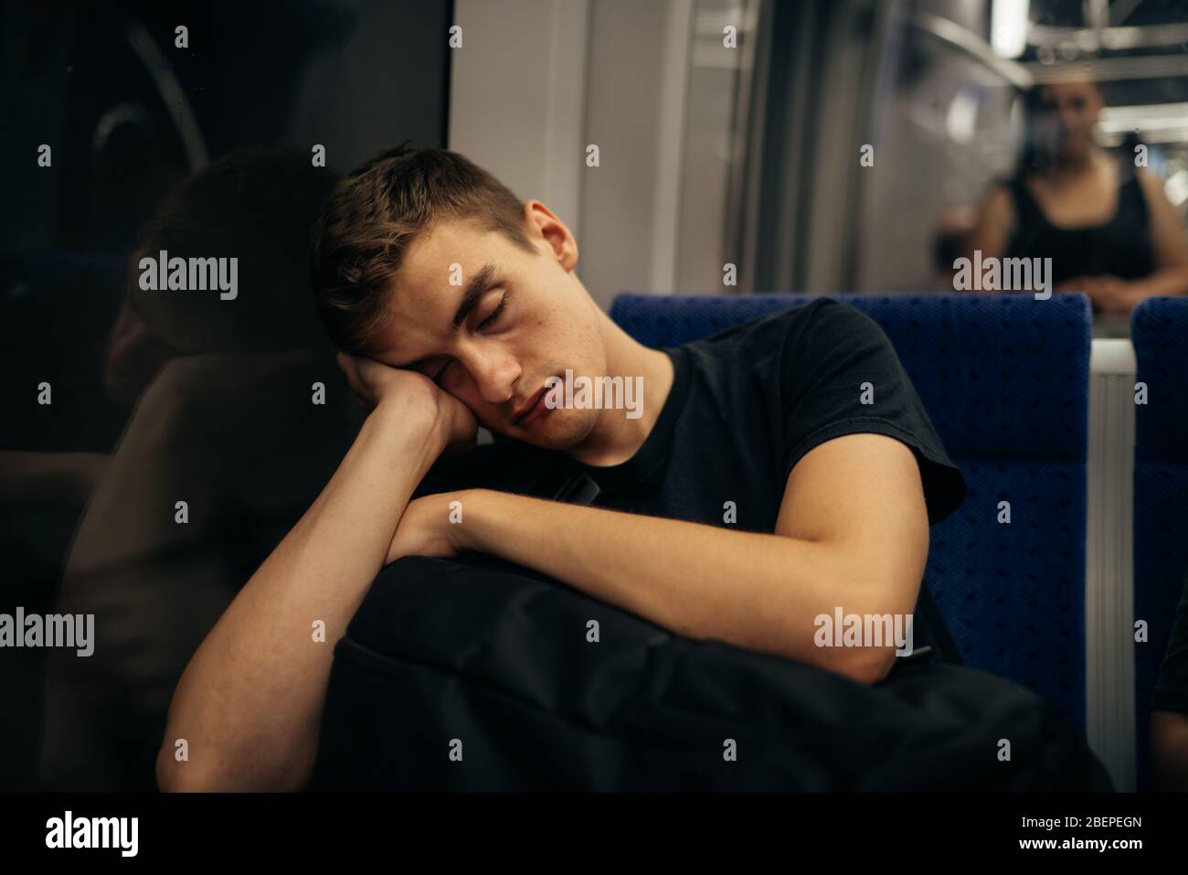Passagier sitzt auf dem Sitz und schläft in einem Zug / Bus während der Reise.müde erschöpft aussehenden jungen Mann immer weg mit der Zugfahrt. Stockfoto