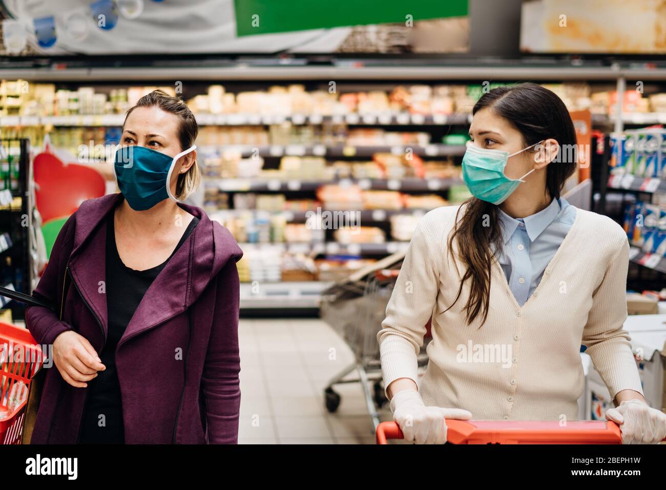 Käufer mit Masken Kauf für Lebensmittel aufgrund von Coronavirus Pandemie im Lebensmittelgeschäft.COVID-19 Lebensmittel einkaufen.Quarantäne Vorbereitung.Panik Kauf und s Stockfoto