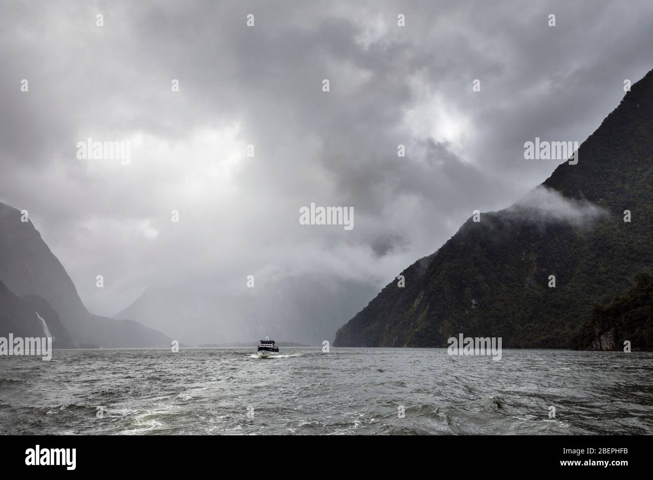 Milford Sound mit Mitre Peak an einem stürmischen Tag von Wolken verdeckt, Fiordland National Park, South Island, Neuseeland Stockfoto