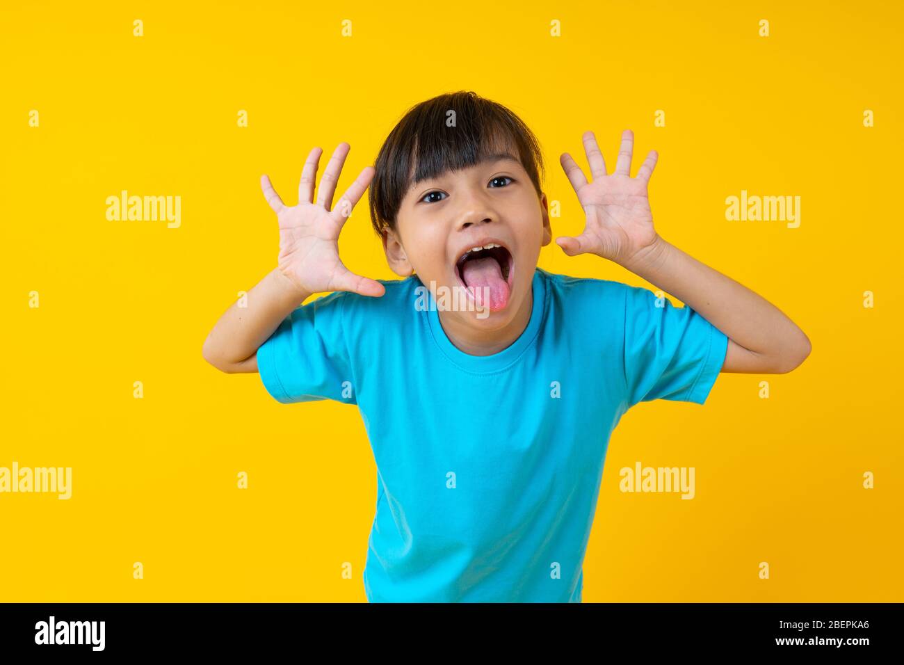 Porträt von jungen asiatischen Mädchen Ausdruck und fröhlich, Thai Kind Spaß und Unschuld auf gelbem Hintergrund haben Stockfoto