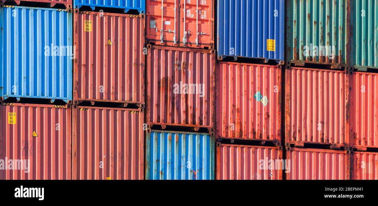 Gestapelte Frachtcontainer, moderne industrielle Schiffsausrüstung Hintergrundfoto Stockfoto