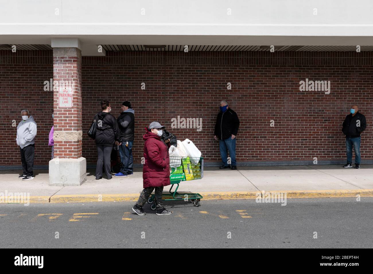 Menschen, die Schutzmasken in der Schlange im Lebensmittelgeschäft, Boston Massachusetts USA tragen Stockfoto