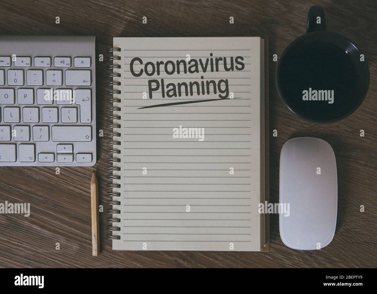 Ein Schreibtisch mit Notebook und Computer mit der Geschäftsplanung für die Zukunft und das vorausschauende Denken wegen Coronavirus mit Kopierraum Stockfoto