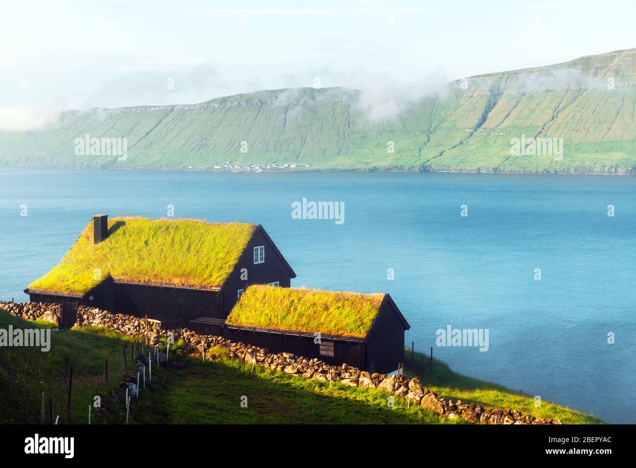 Nebeliger Blick auf ein Haus mit Grasdach im Dorf Velbastadur auf der Insel Streymoy, den Inseln der Färöer, Dänemark. Landschaftsfotografie Stockfoto