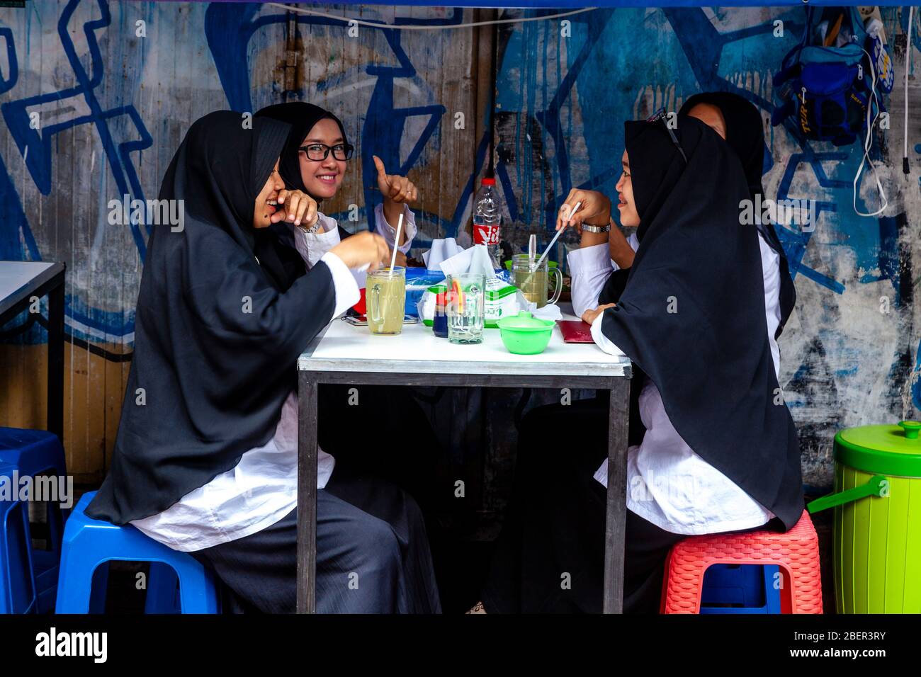 Junge indonesische Frauen trinken alkoholfreie Getränke in EINEM Café an der Malioboro Street, Yogyakarta, Indonesien. Stockfoto