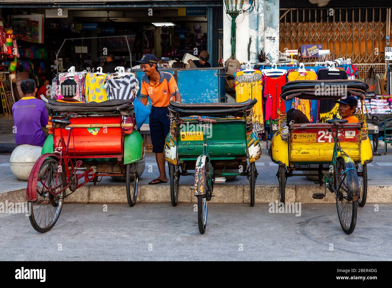 Bunte Bekaken (Radrickschas) und ihre Fahrer, Malioboro Street, Yogyakarta, Indonesien. Stockfoto