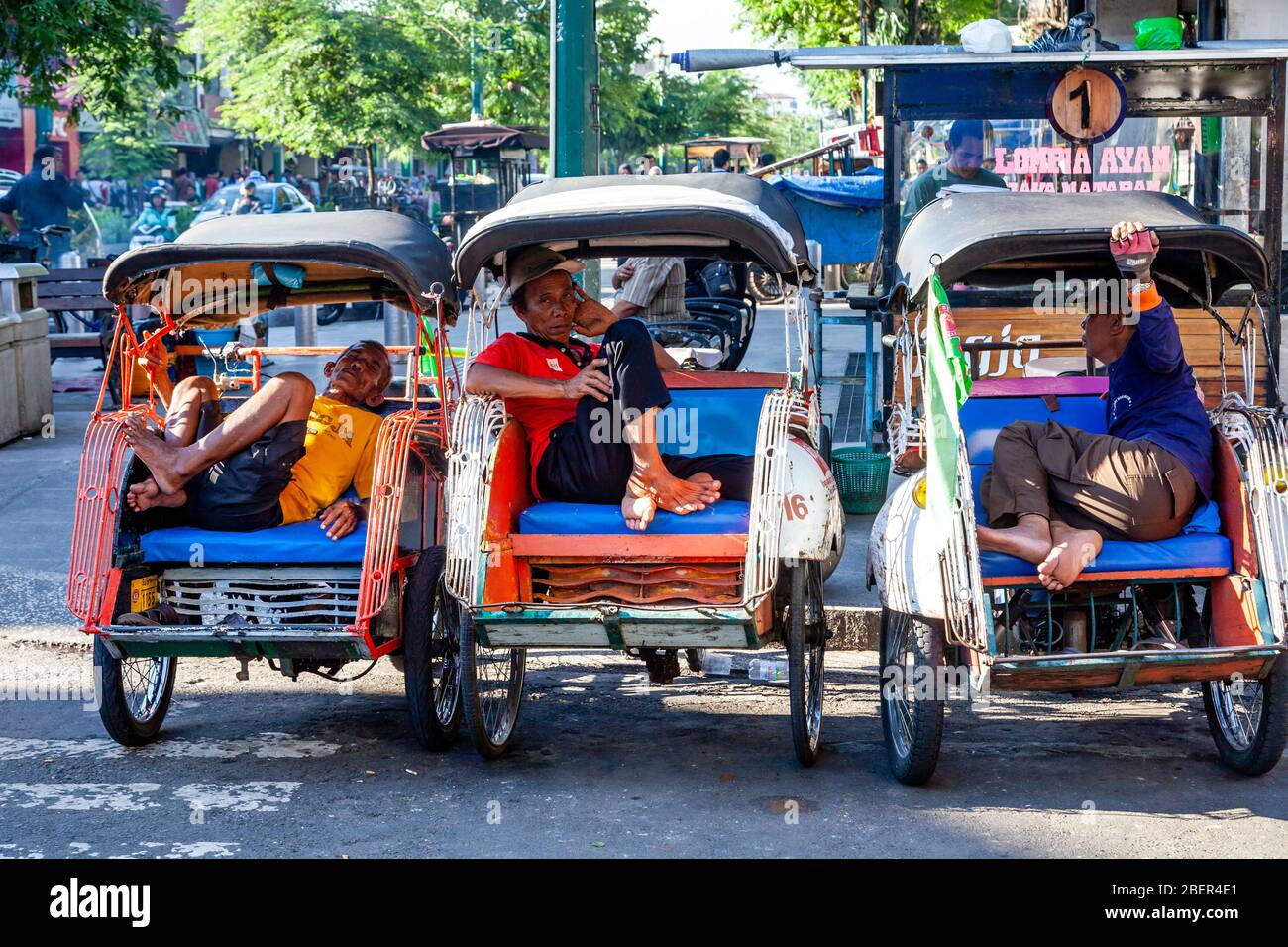 Becak (Cycle Rickshaw) und Motorrad Taxi Drivers Ruhen, Yogyakarta, Java, Indonesien. Stockfoto