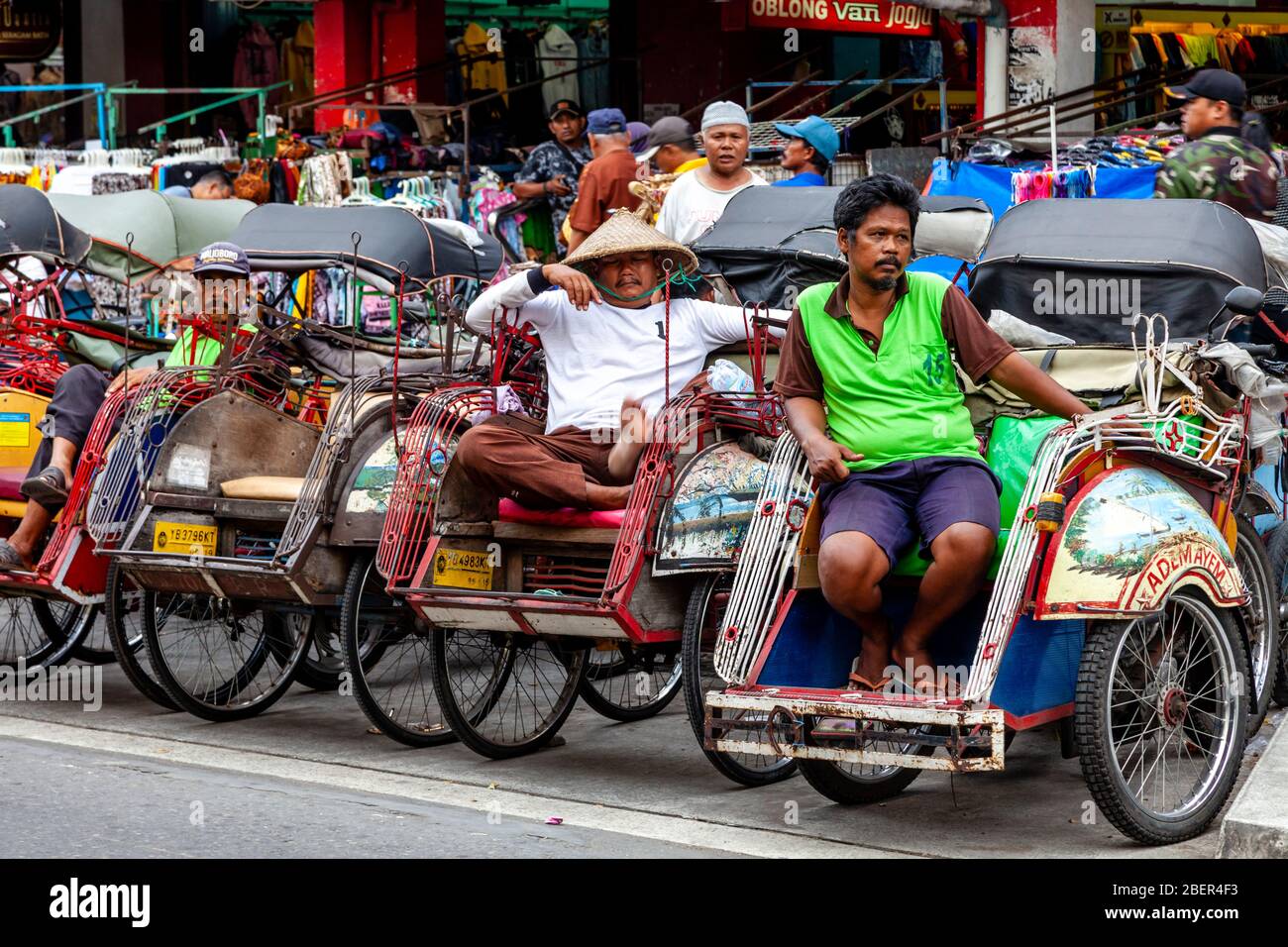 Becak (Cycle Rickshaw) und Motorrad Taxi Fahrer warten auf Business, Malioboro Street, Yogyakarta, Java, Indonesien. Stockfoto