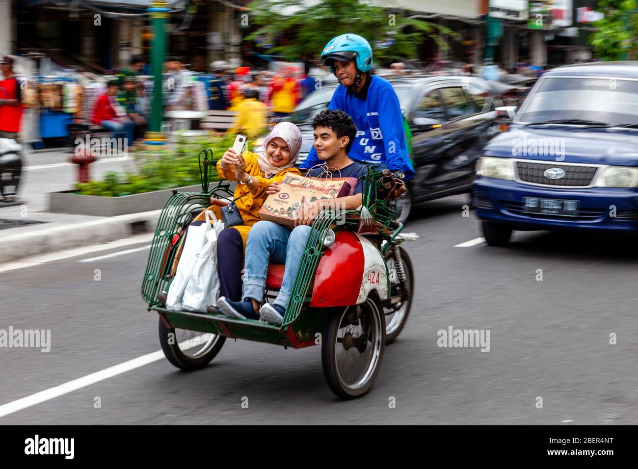 Ein Motorrad-Taxi und Passagiere, Malioboro Street, Yogyakarta, Indonesien. Stockfoto