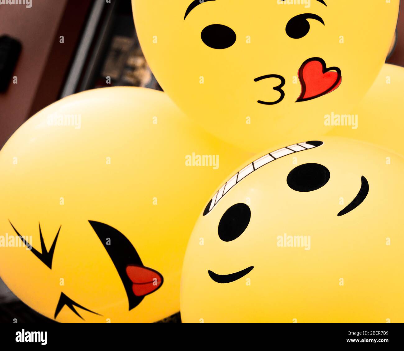 Lustige, gelbe Emoji-Ballons, die bei einer Straßenparty in Senigallia, Le Marche, Italien zusammengebündelt wurden Stockfoto