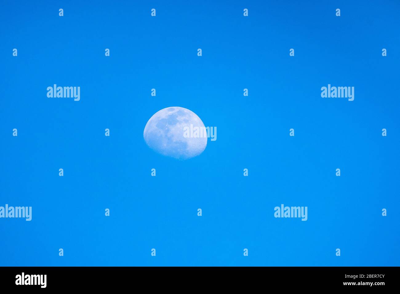 Verschwommener Mond am blauen Himmel eines sonnigen Tages. Mond mit dem blauen Himmel des Tages. Stockfoto