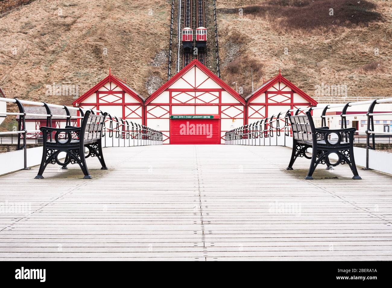 Blick von einem verlassenen Saltburn Pier vorbei an leeren Bänken auf die Cliff Railway Stockfoto