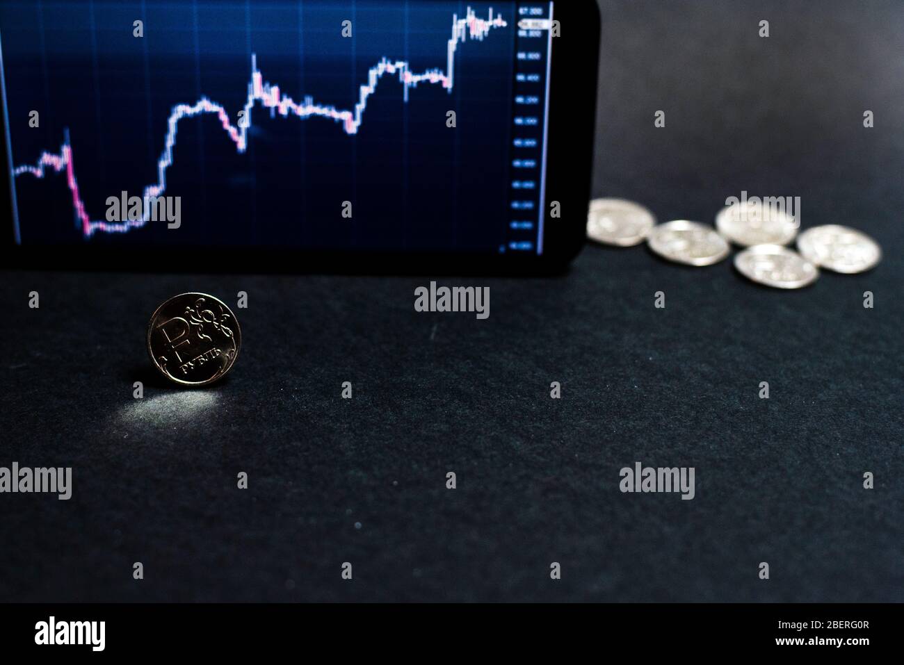Rubelmünze vor dem Hintergrund des Wachstumsgraphen des Rubel- zum Dollarkurses. Das Konzept der Überwindung der Wirtschaftskrise. Stockfoto